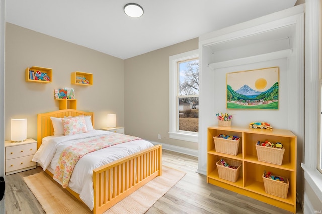 bedroom featuring baseboards and wood finished floors