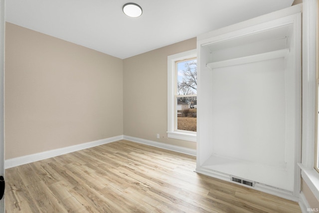 interior space featuring light wood-type flooring, baseboards, and visible vents