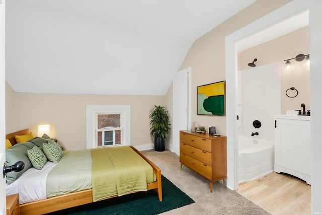 bedroom with vaulted ceiling, a sink, and baseboards