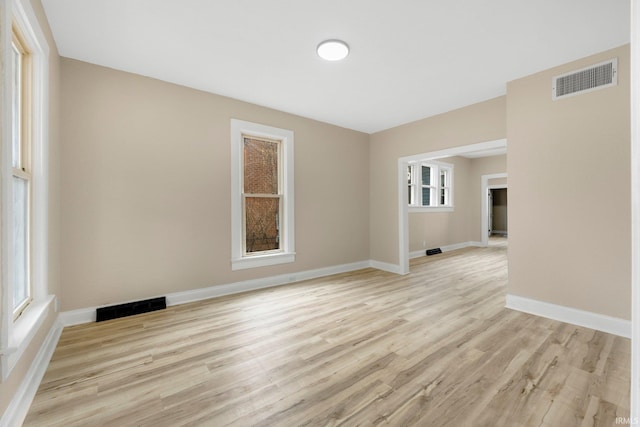 spare room with baseboards, visible vents, and light wood-style floors