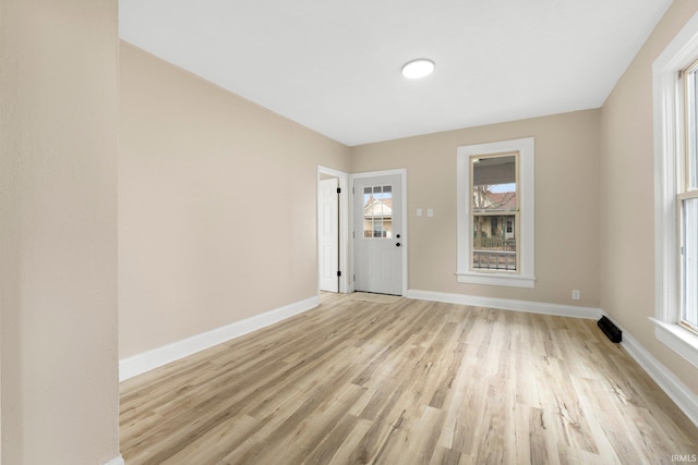 interior space featuring light wood finished floors, plenty of natural light, and baseboards