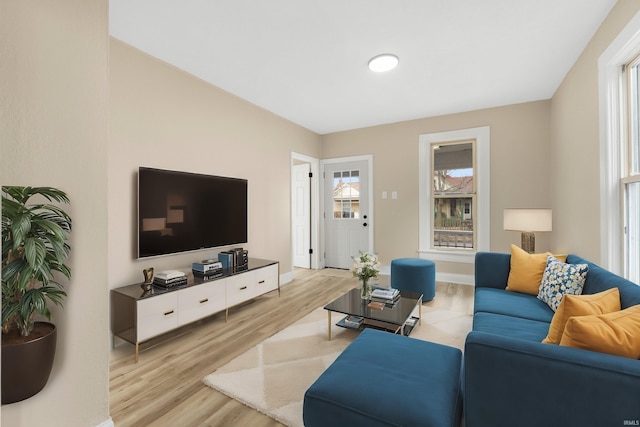 living area featuring light wood-style floors and baseboards