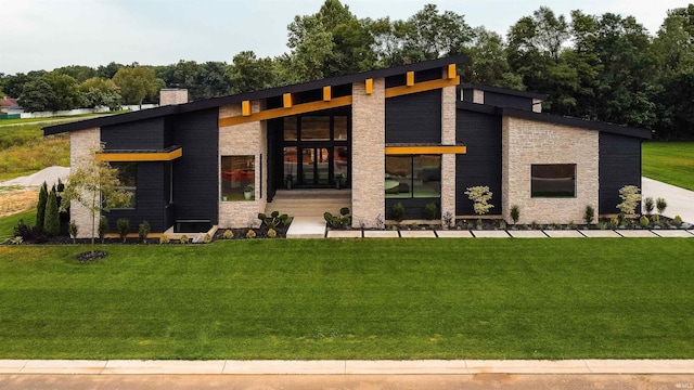 view of front of home featuring stone siding, a chimney, and a front lawn