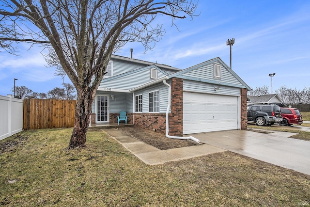 traditional-style home featuring a garage, brick siding, fence, driveway, and a front yard