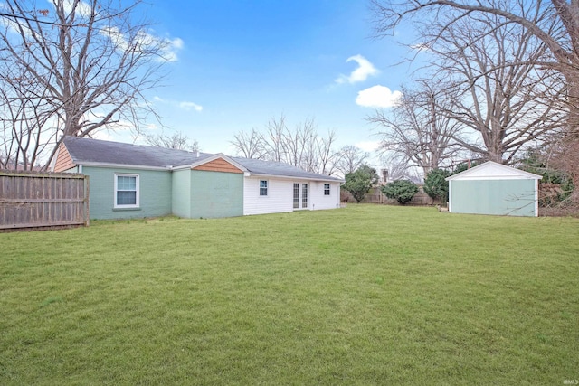 back of house with a storage shed, brick siding, an outdoor structure, fence, and a yard