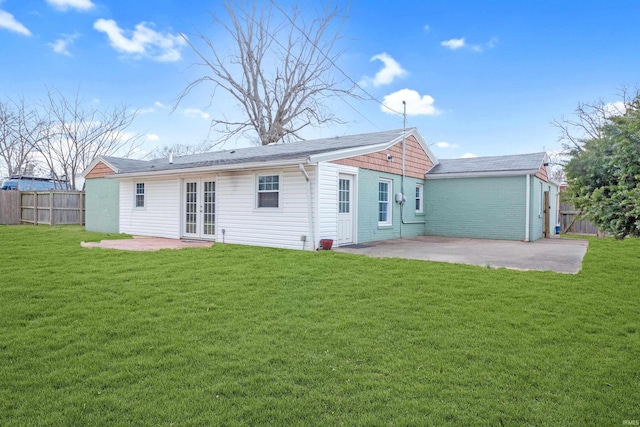 back of property with a lawn, fence, french doors, and a patio