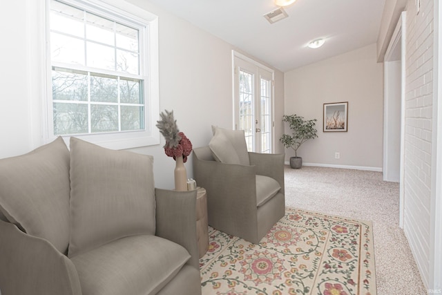 sitting room featuring lofted ceiling, carpet, visible vents, and baseboards