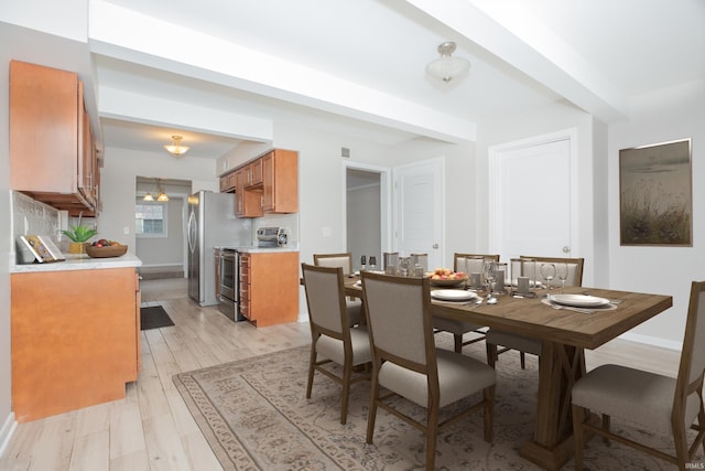 dining space featuring light wood-type flooring, visible vents, a notable chandelier, and baseboards