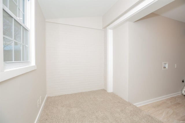 unfurnished room featuring vaulted ceiling and light carpet