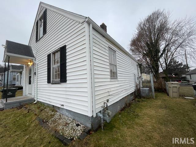 view of home's exterior with a lawn and a chimney