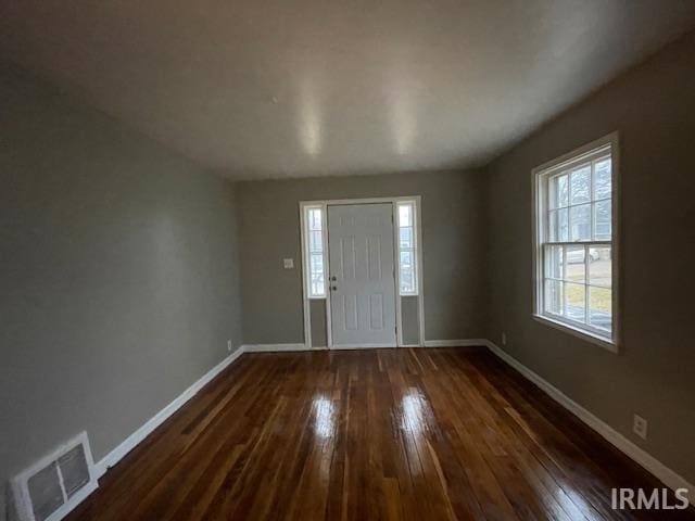 entryway with dark wood-style floors, visible vents, and baseboards