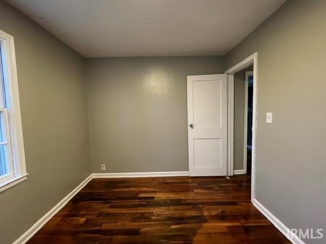 unfurnished room with wood finished floors and baseboards