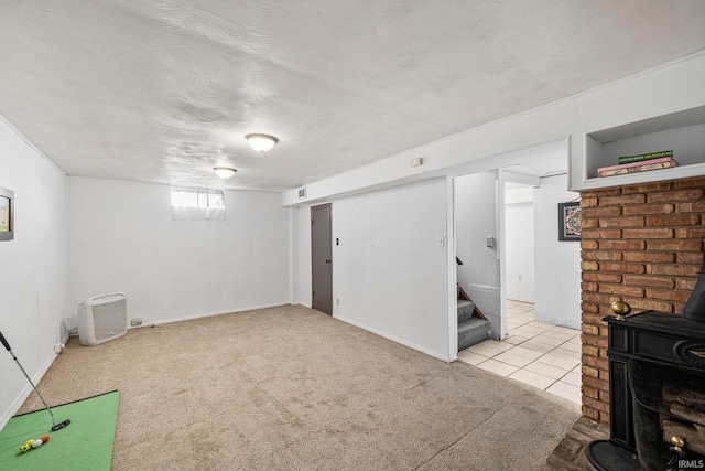 below grade area featuring carpet floors, stairway, a wood stove, a textured ceiling, and tile patterned flooring