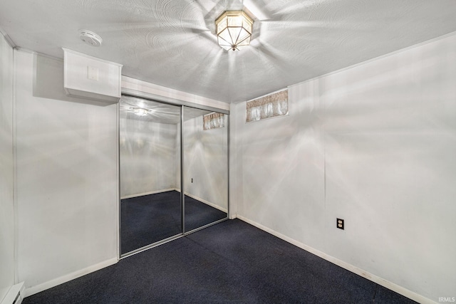 interior space featuring baseboards, dark carpet, baseboard heating, and a closet