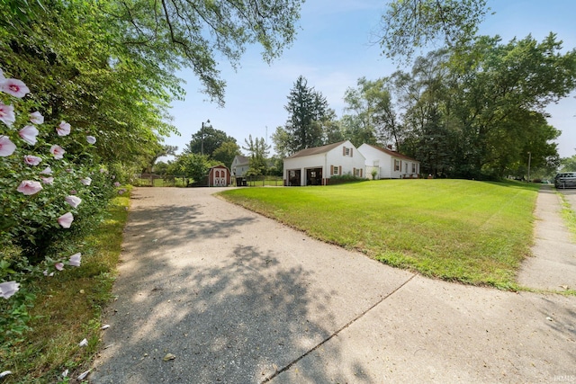 exterior space with gravel driveway, a storage shed, an outbuilding, and a front yard