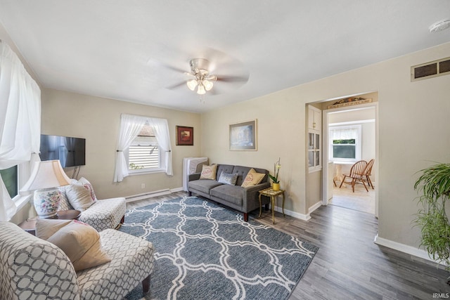 living room featuring ceiling fan, wood finished floors, visible vents, and a healthy amount of sunlight