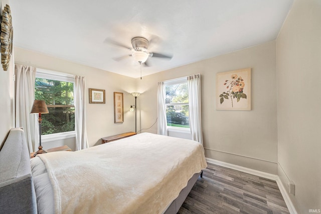 bedroom with dark wood-style floors, baseboards, and a ceiling fan