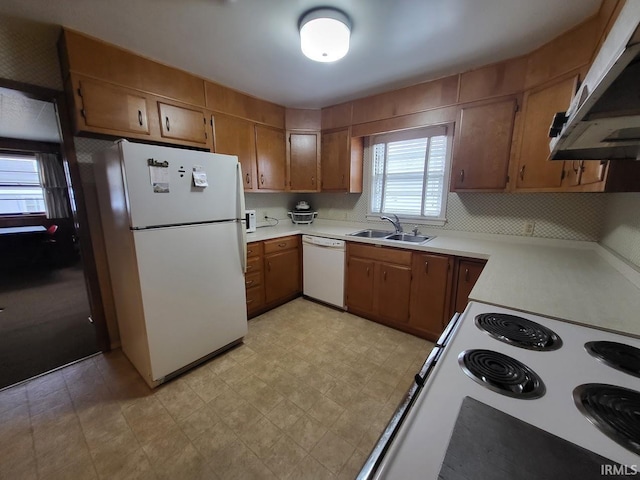 kitchen featuring a sink, white appliances, brown cabinetry, and exhaust hood