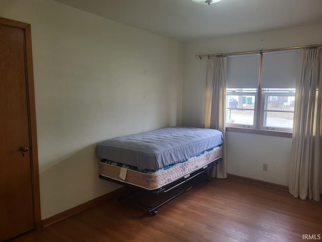 bedroom featuring baseboards and wood finished floors