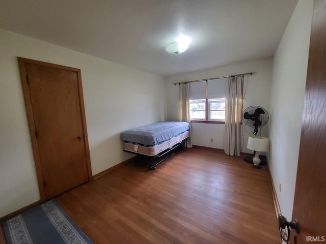 bedroom with baseboards and wood finished floors