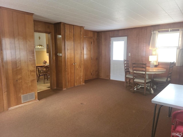 interior space featuring wood walls, visible vents, and a healthy amount of sunlight