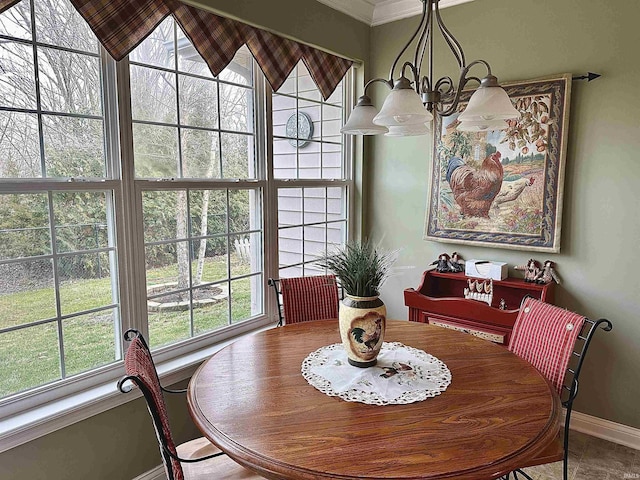 dining space featuring a wealth of natural light, crown molding, baseboards, and an inviting chandelier