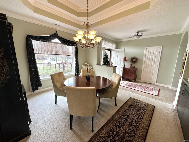 carpeted dining room featuring a textured ceiling, baseboards, visible vents, and crown molding