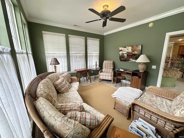 carpeted living area featuring a ceiling fan, visible vents, crown molding, and a textured ceiling