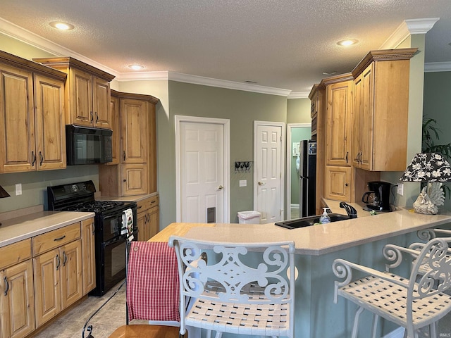 kitchen with a kitchen breakfast bar, light countertops, crown molding, and black appliances