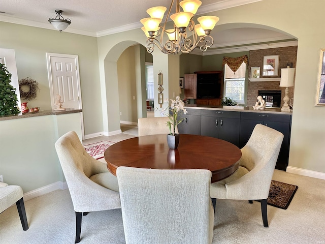 dining space with light carpet, baseboards, ornamental molding, and arched walkways