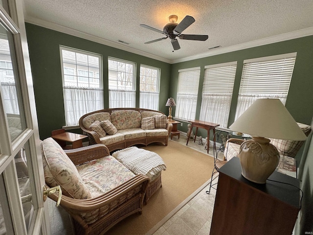 sunroom / solarium featuring a ceiling fan, visible vents, and plenty of natural light