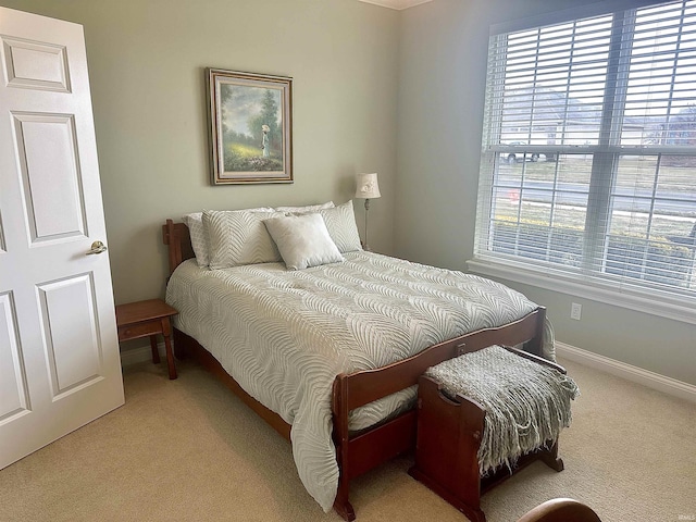 bedroom with light carpet and baseboards