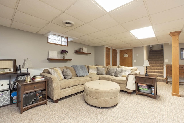 carpeted living room with a paneled ceiling, visible vents, stairway, and wainscoting