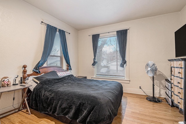 bedroom with baseboards and wood finished floors