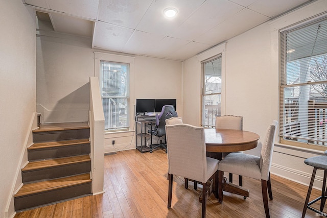 dining area with stairway, baseboards, and hardwood / wood-style flooring