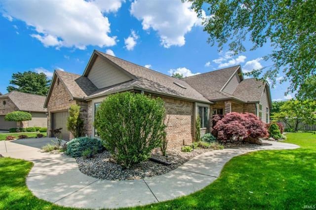 view of home's exterior with an attached garage, driveway, a lawn, and brick siding