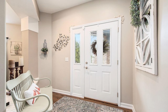 foyer entrance featuring baseboards and dark wood-type flooring