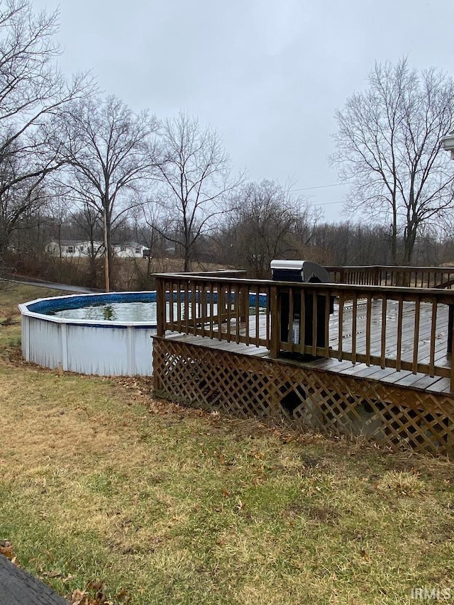 wooden terrace featuring an outdoor pool and a yard