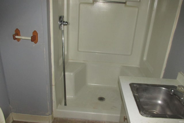 full bathroom with a stall shower and a sink