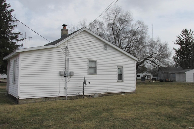 view of property exterior with a chimney and a lawn