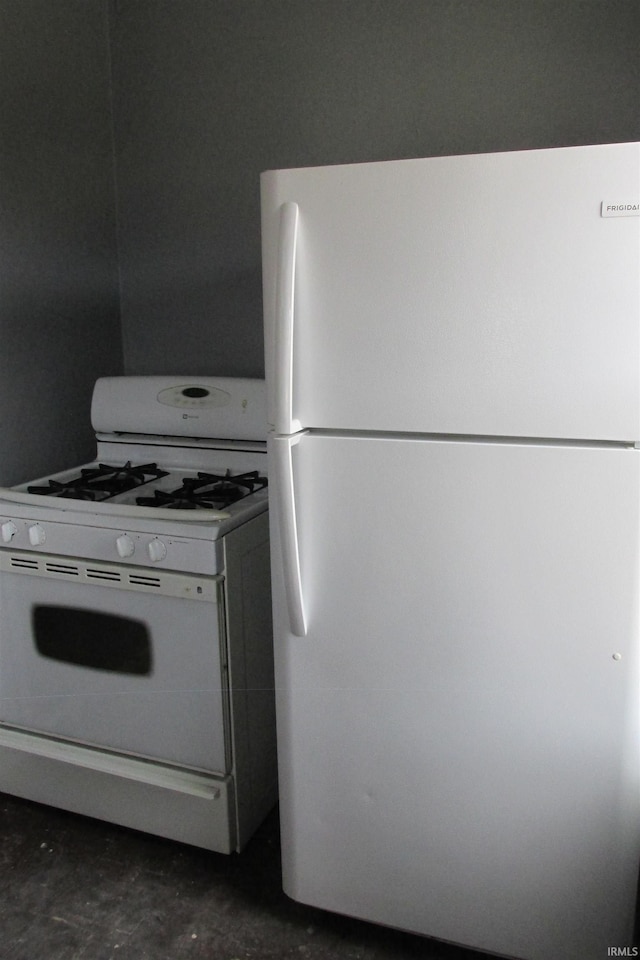 kitchen with white appliances and unfinished concrete flooring