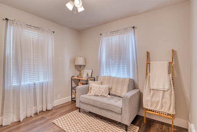 living area featuring plenty of natural light, baseboards, and wood finished floors