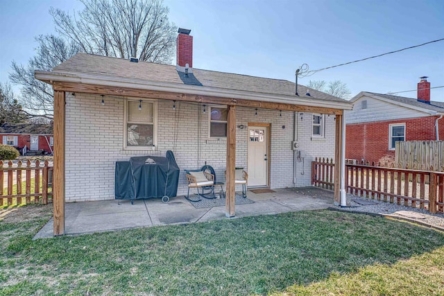 rear view of house with a patio area, fence, and a lawn