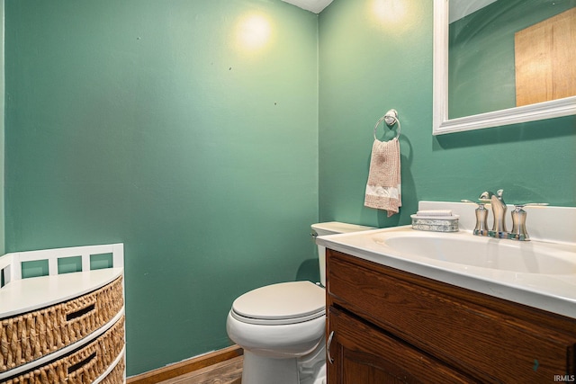 bathroom featuring toilet, wood finished floors, and vanity