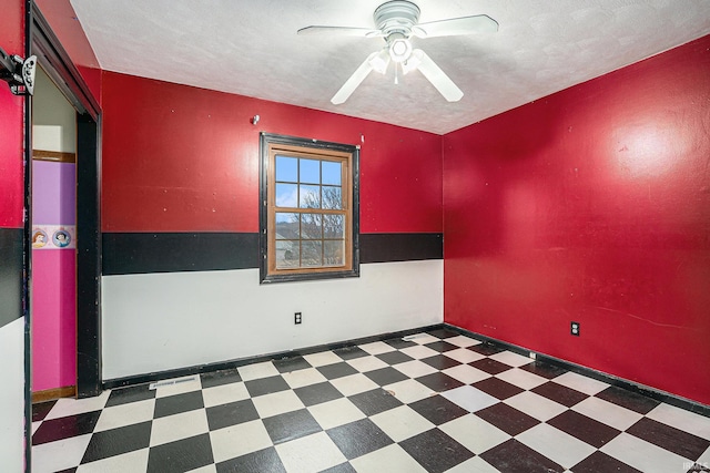 spare room featuring ceiling fan, baseboards, a textured ceiling, and tile patterned floors