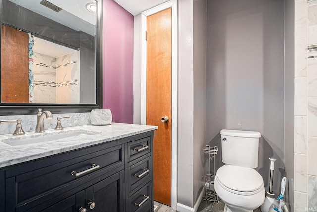 bathroom featuring toilet, visible vents, and vanity