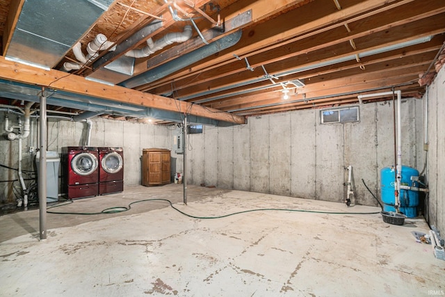 unfinished below grade area featuring electric panel and washer and clothes dryer