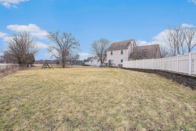 view of yard with a fenced backyard and a playground