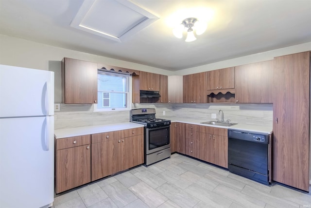 kitchen with black dishwasher, freestanding refrigerator, under cabinet range hood, stainless steel range with gas cooktop, and a sink