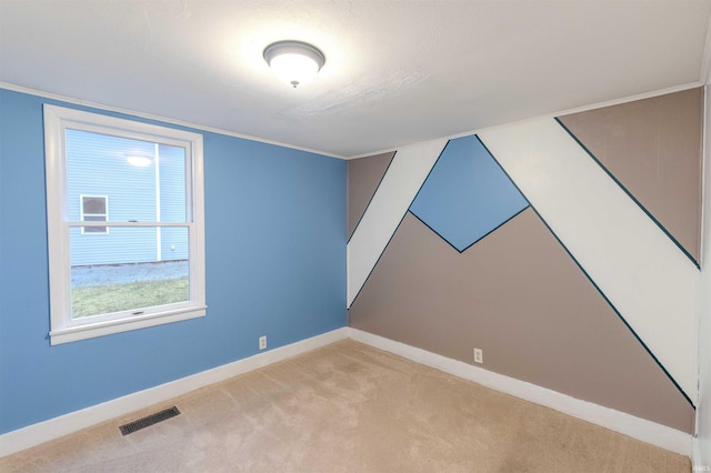 carpeted empty room featuring baseboards, visible vents, and ornamental molding